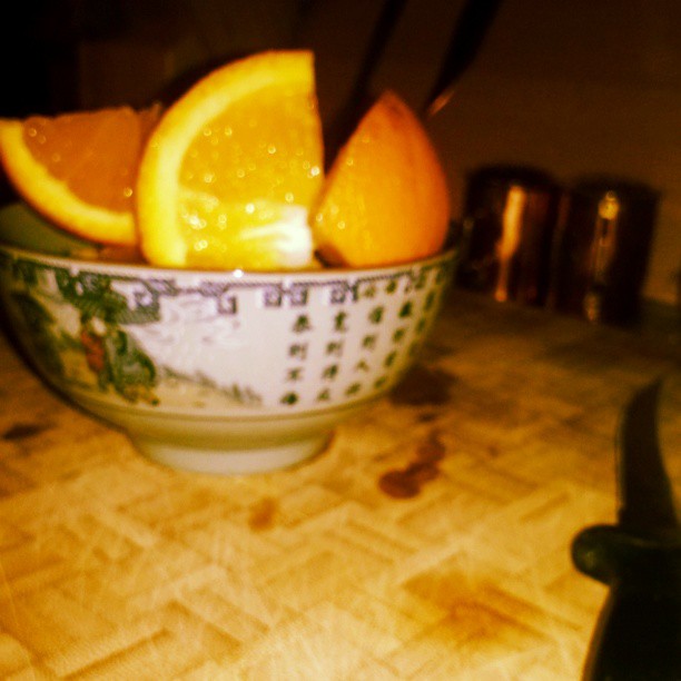 a bowl with oranges in it sitting on a counter top