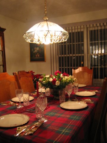 a table set for christmas with place settings and plates