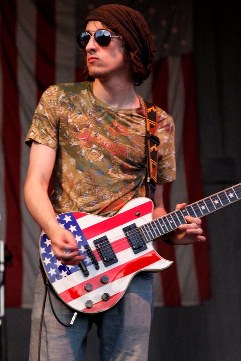 a man with sunglasses and an american guitar