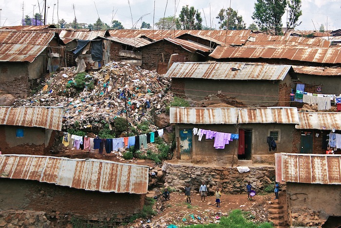 dirty brown roofs and tin roofed buildings with laundry hanging in front