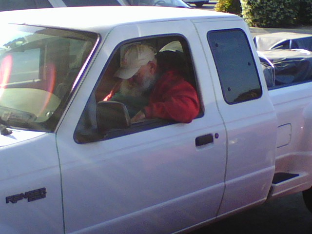 man in white truck with red shirt in driveway