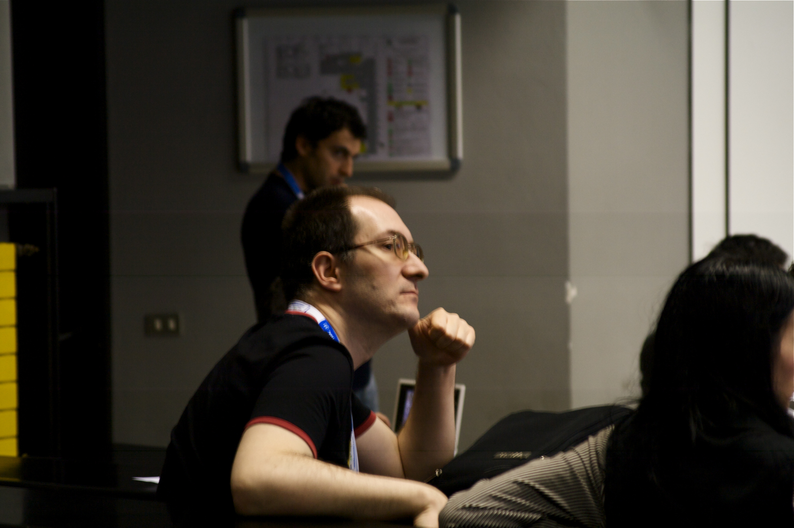 a man sitting at a table with his hands resting on his chin