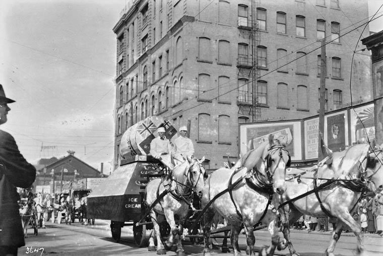 a black and white po of horse drawn carriages in a city