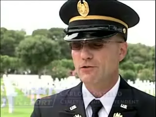 an officer is in uniform standing near a cemetery