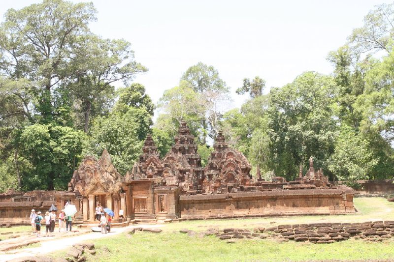 people walking around in front of temples on a sunny day