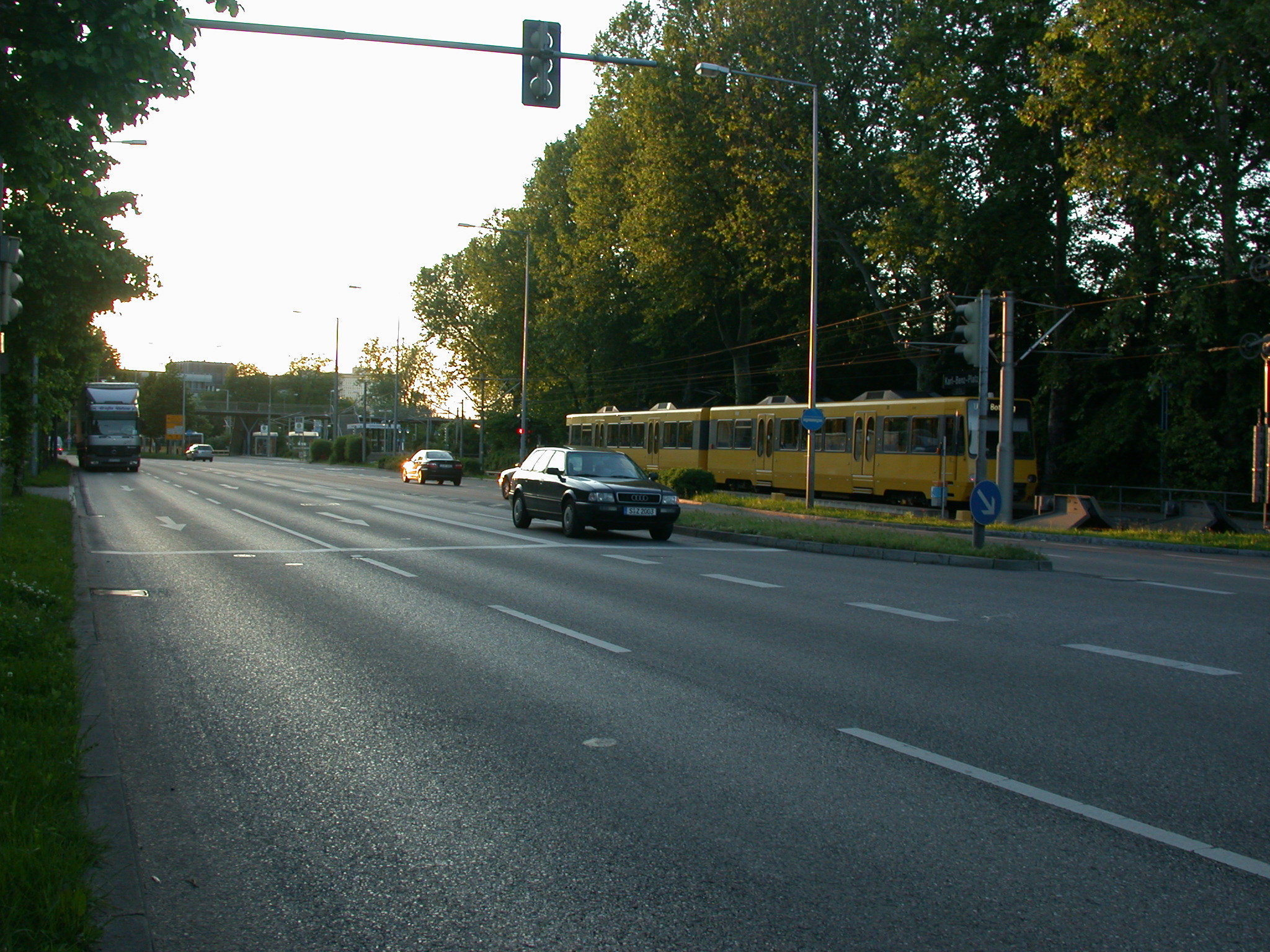 an intersection with a busy street and a train on the tracks