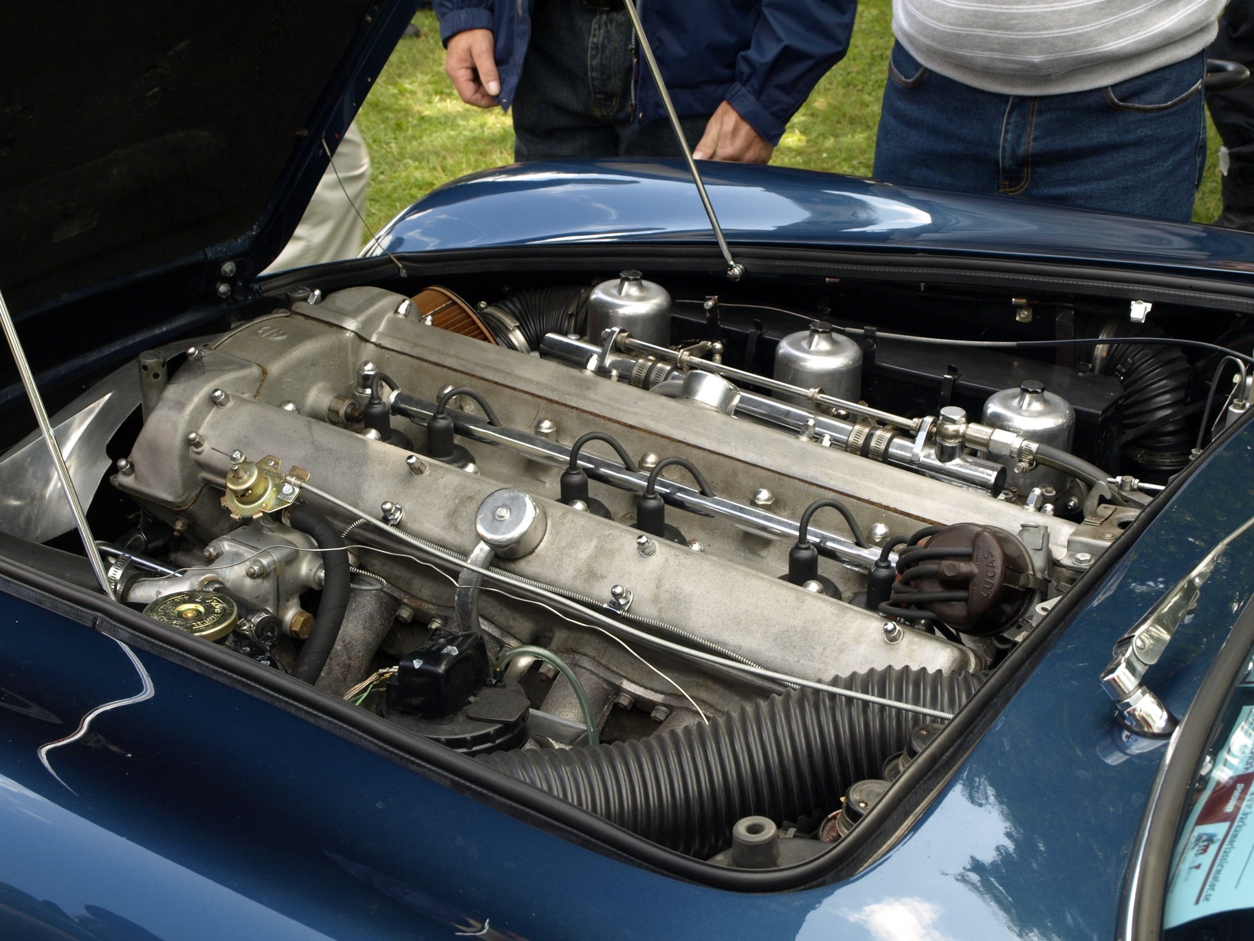 people are looking at an engine bay of a car