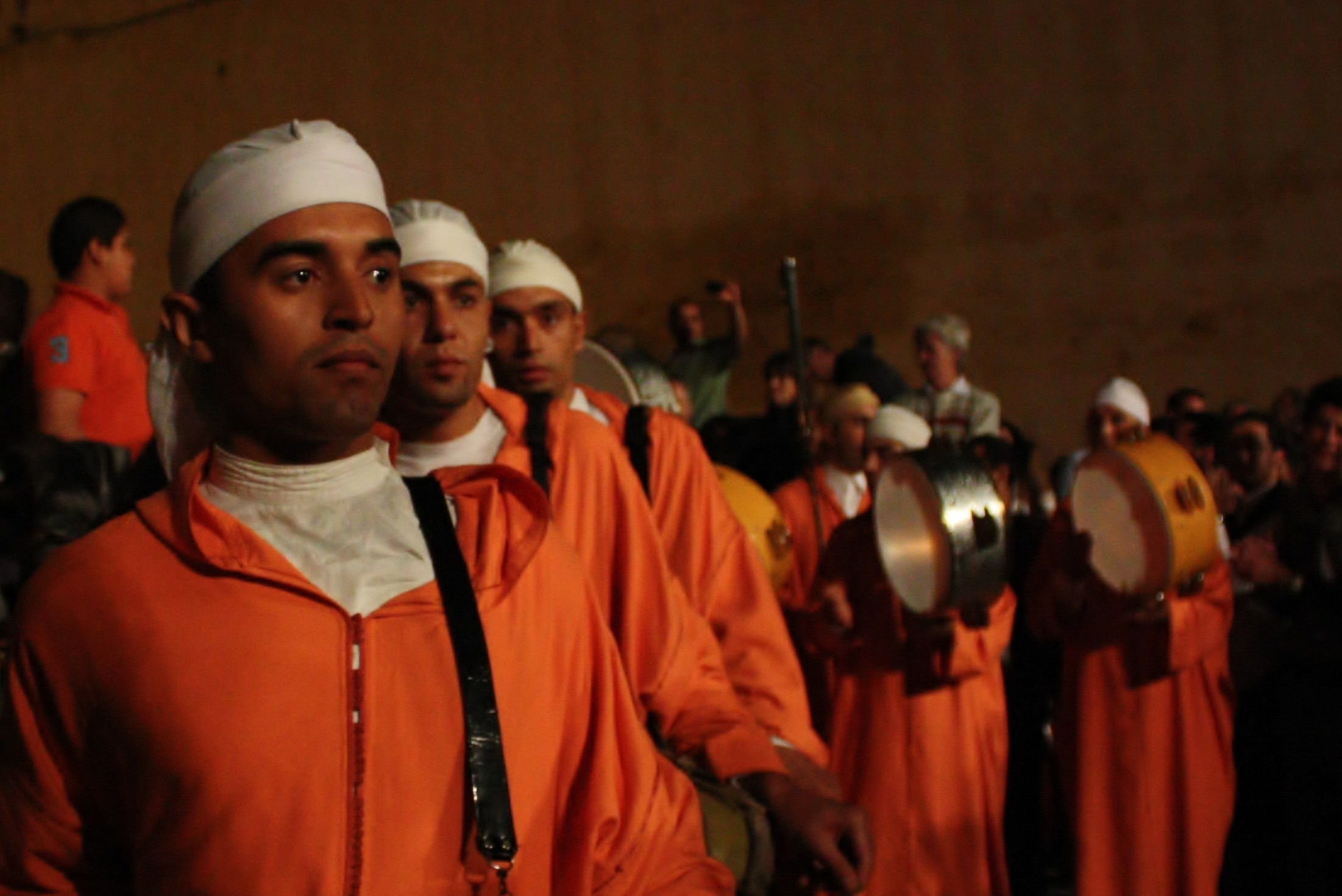 people in orange uniforms and turbans standing together