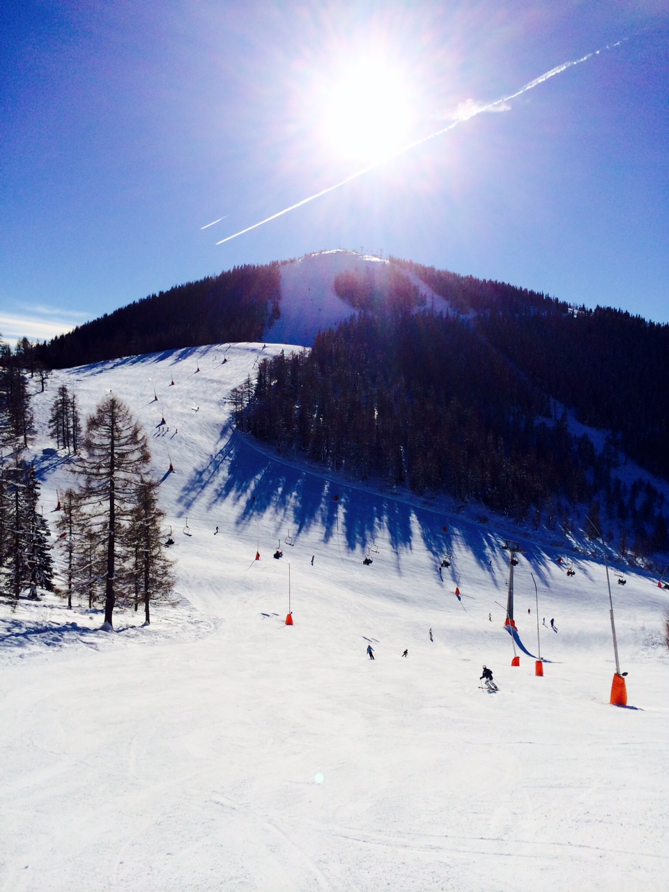 the sun is shining down on a small ski slope