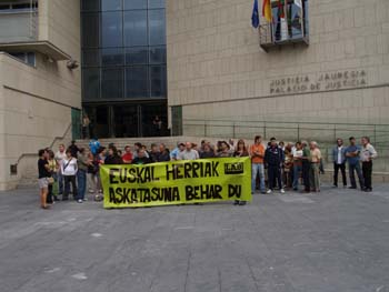 a group of people with yellow signs in front of a building