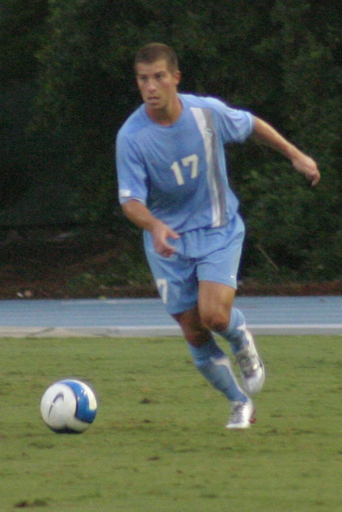 a young man running after a soccer ball