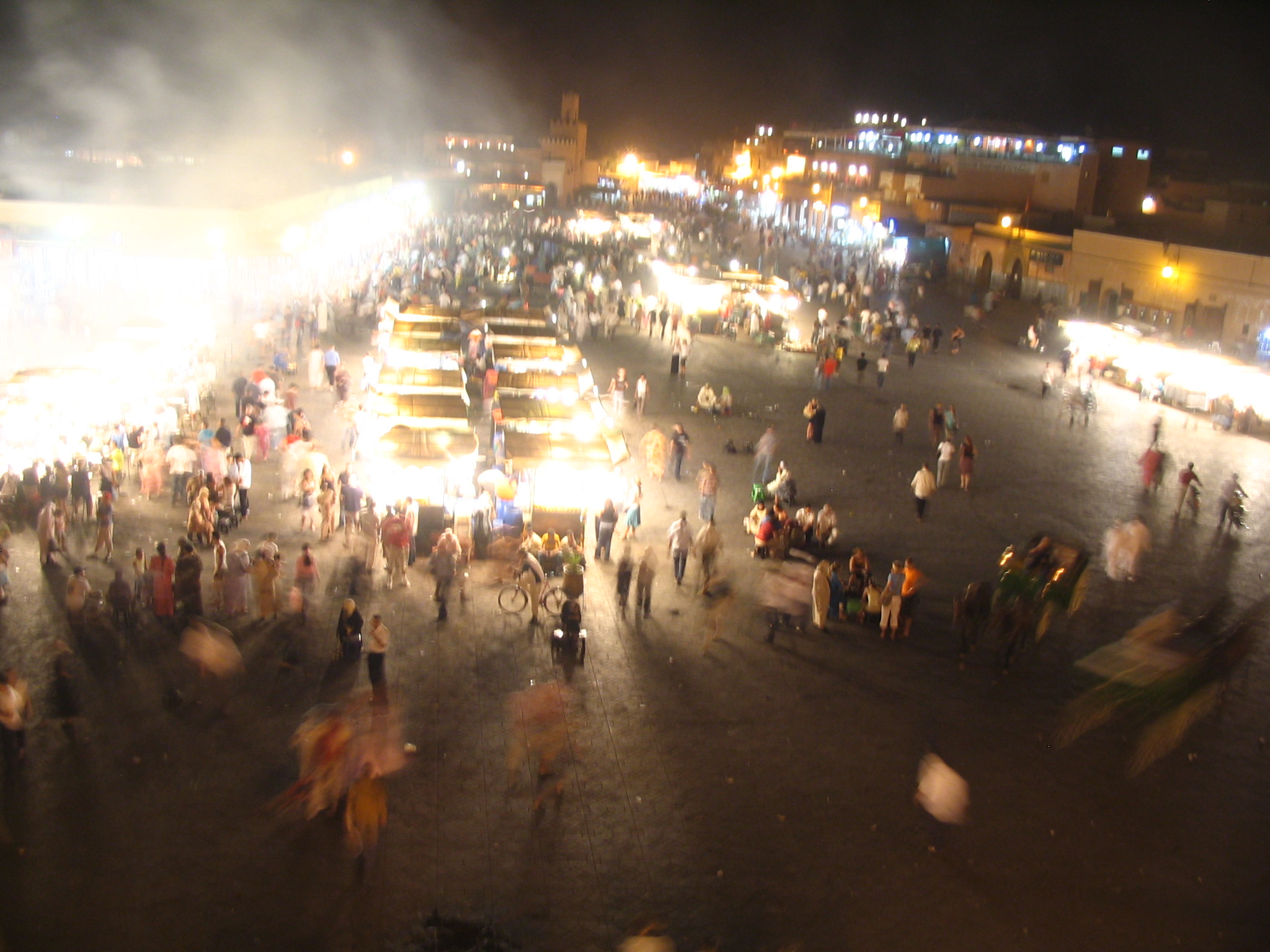 an image of a city at night with many people around