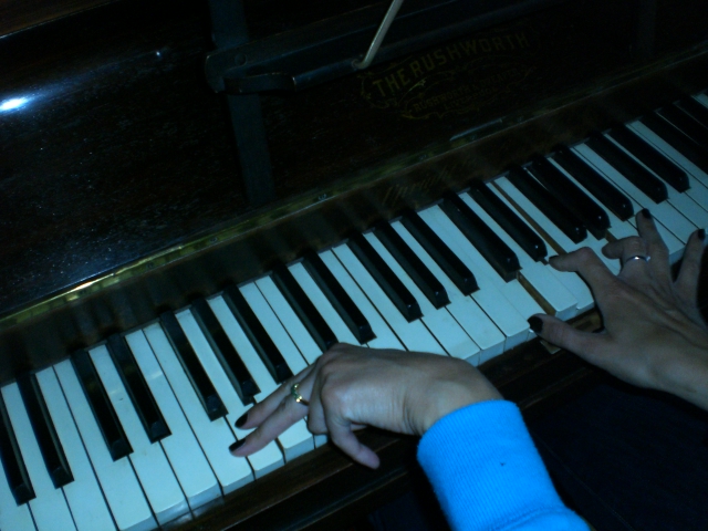 a person reaching their hand to play the piano