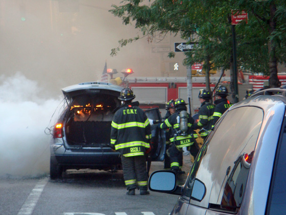 some fire fighters near cars and some trucks