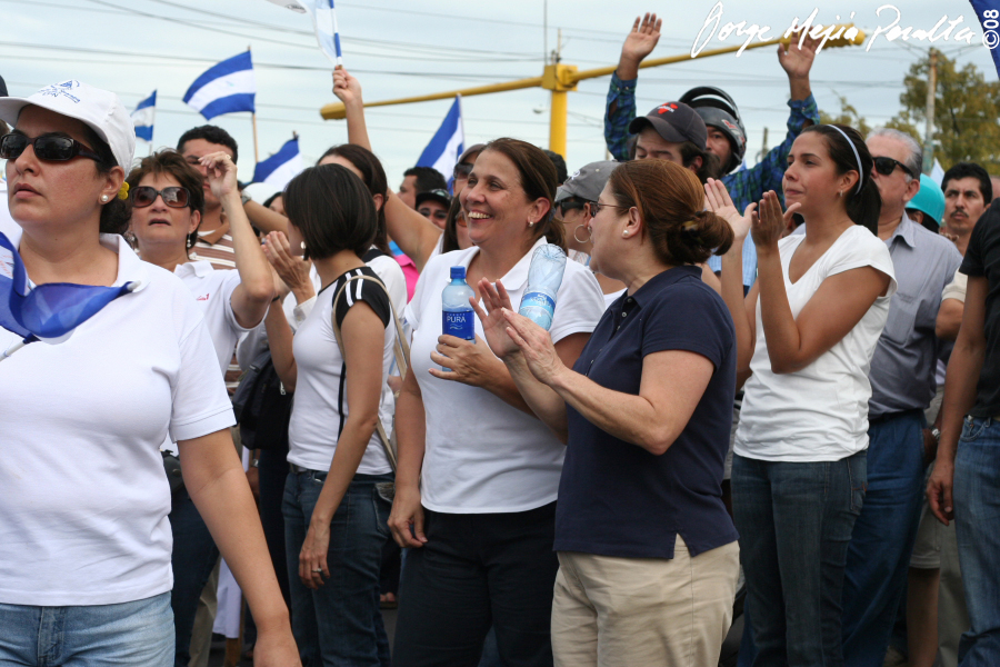 women standing in a crowd waving and talking