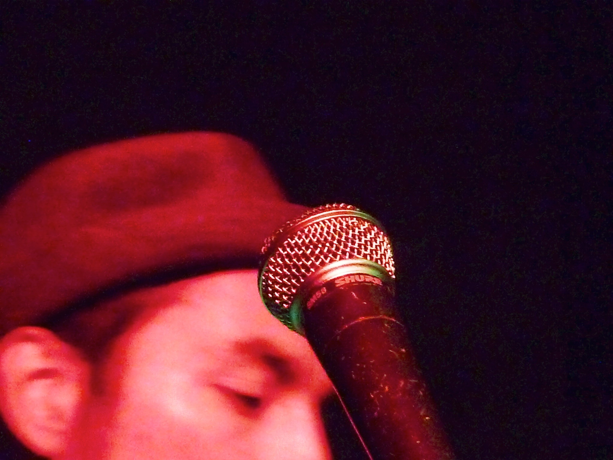 a man in a red hat is holding a microphone