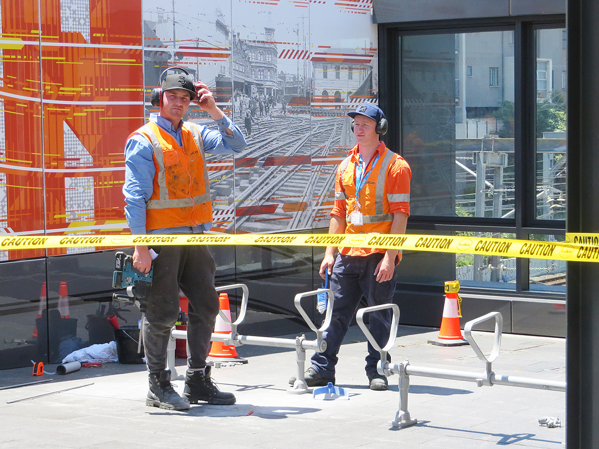 construction workers standing next to a train track