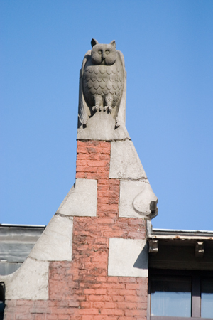 an owl statue on top of a brick building