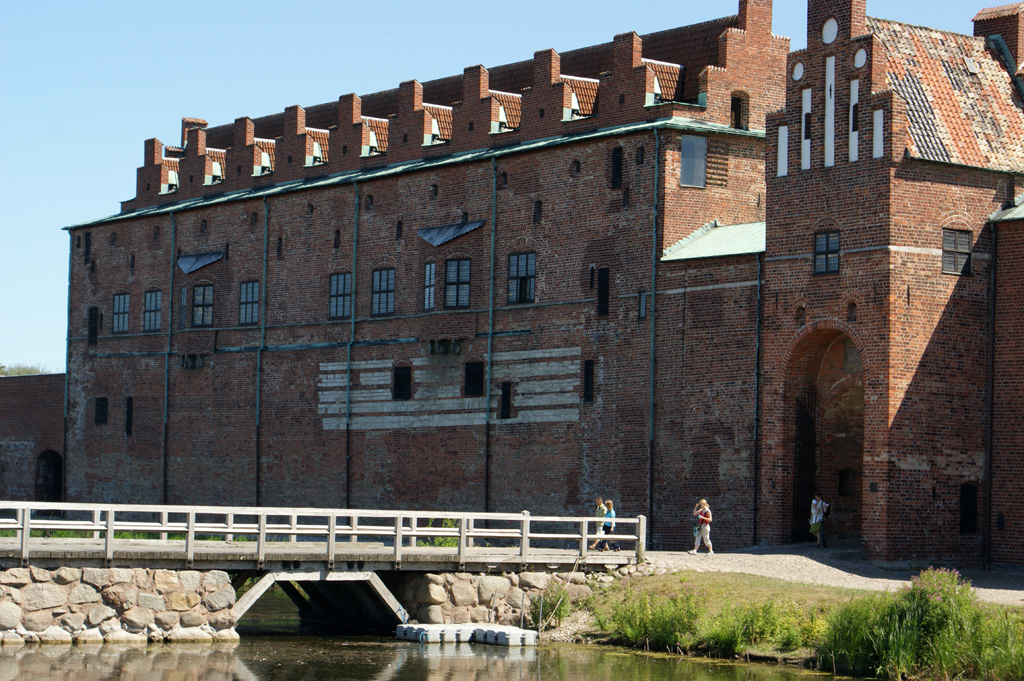 a bridge crosses over a body of water near an old brick building