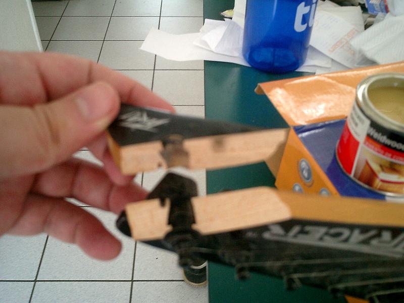 a hand holding small wooden airplanes next to a can of paint