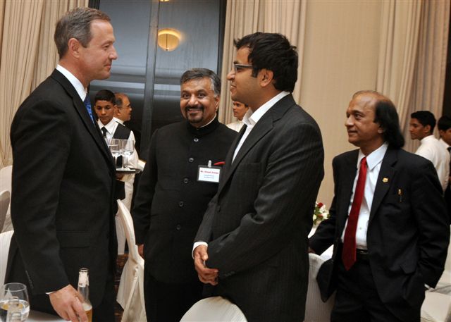 a man in suit talking to others at a banquet
