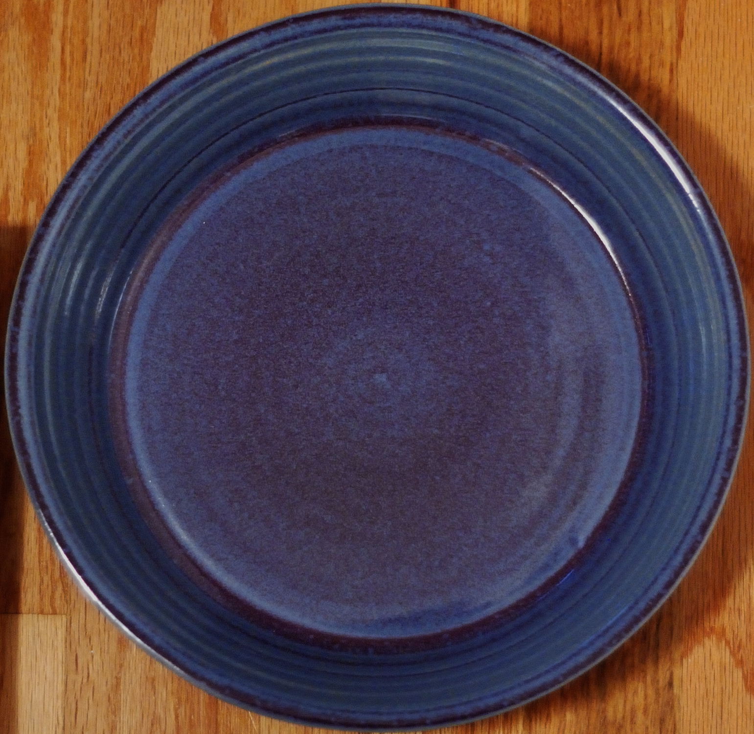 a blue plate is sitting on a wooden table