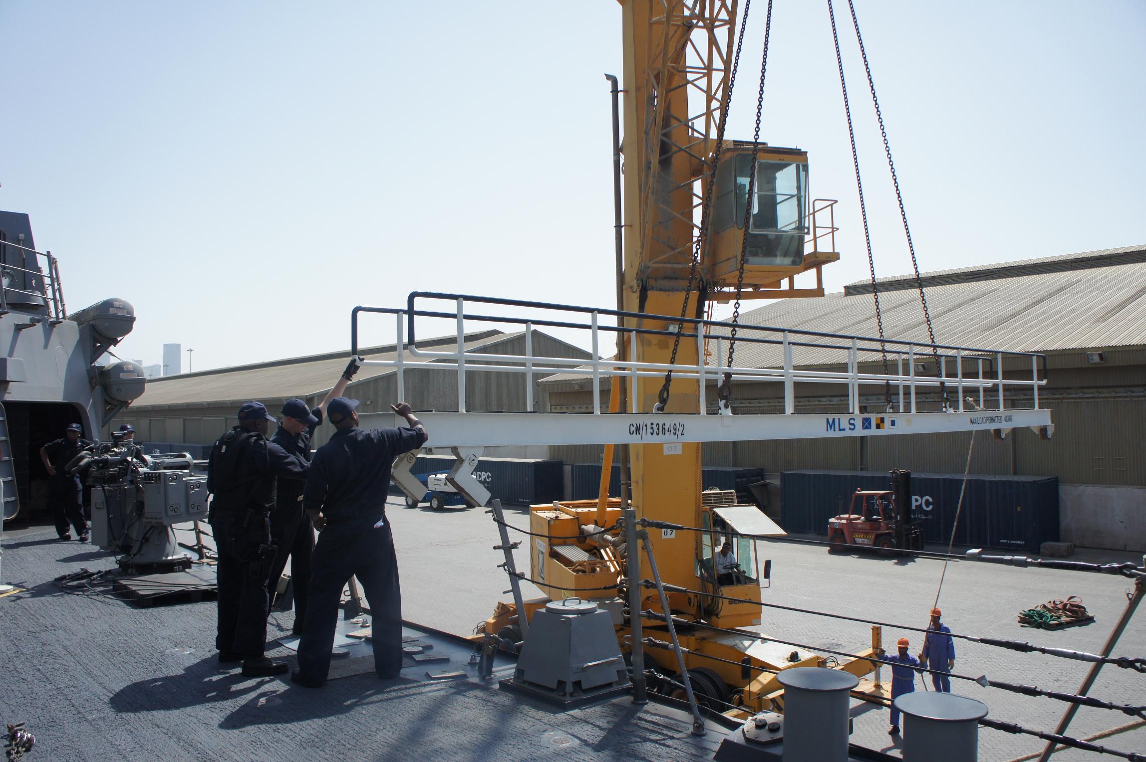 two men are standing outside of a crane