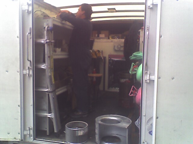 man standing in the doorway of an enclosed vehicle