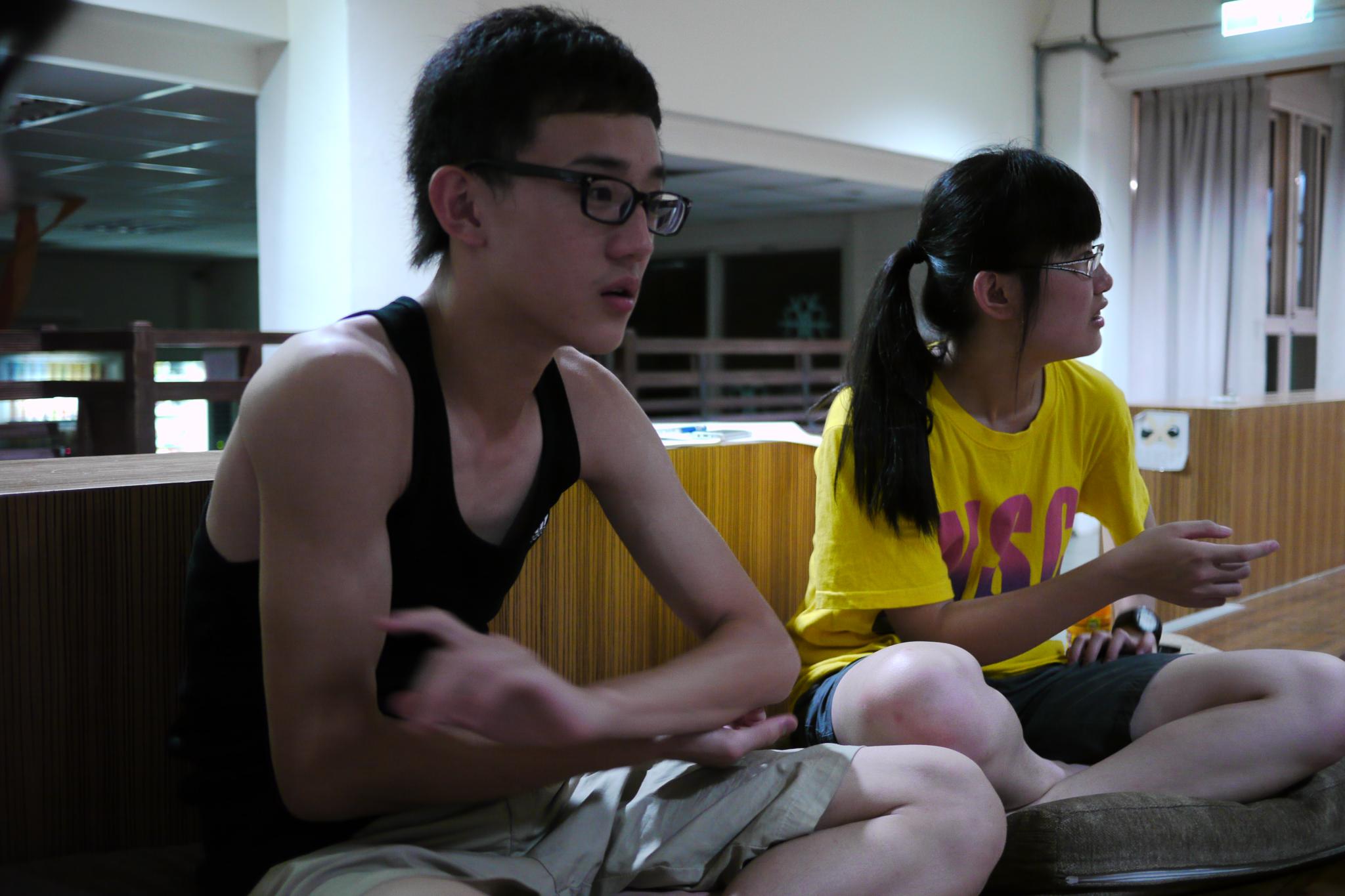 two people sitting and playing video games at a public event