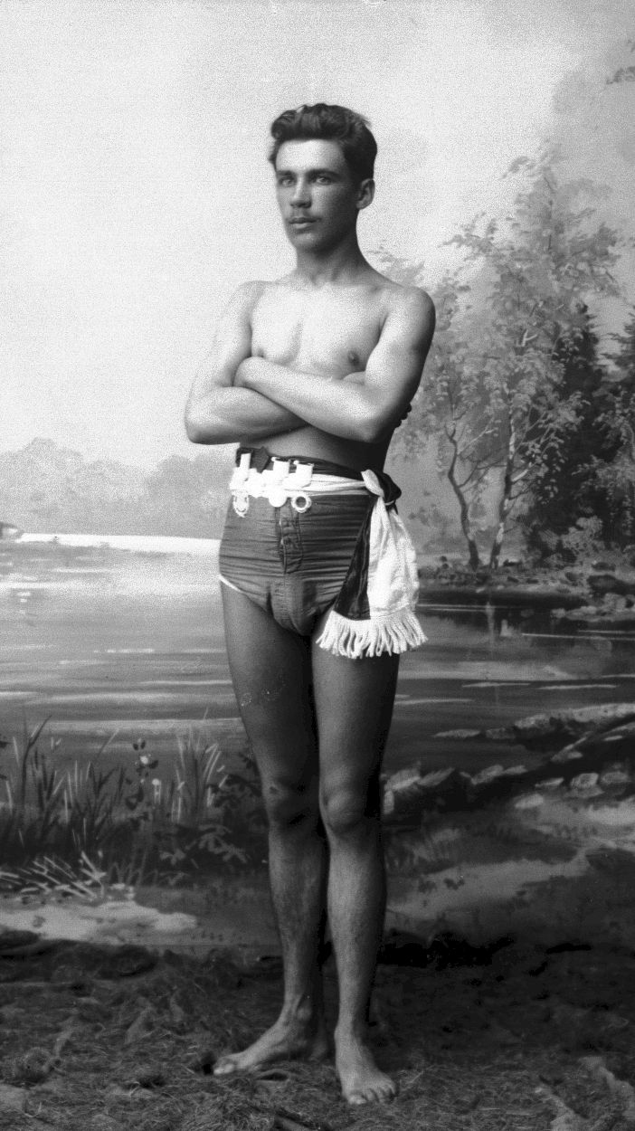 a man standing in his underwear in front of a large painting
