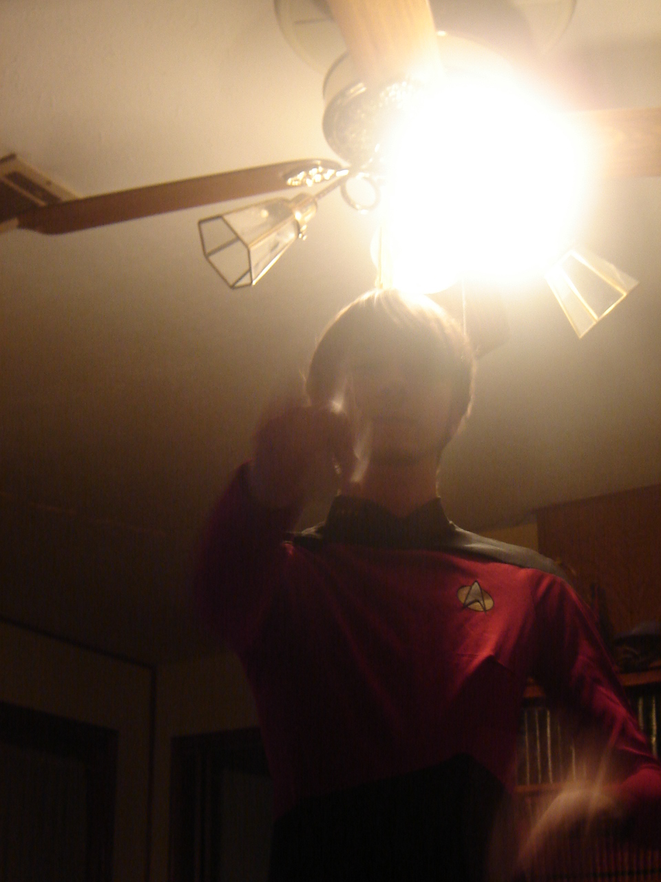 a person stands in front of the ceiling fan