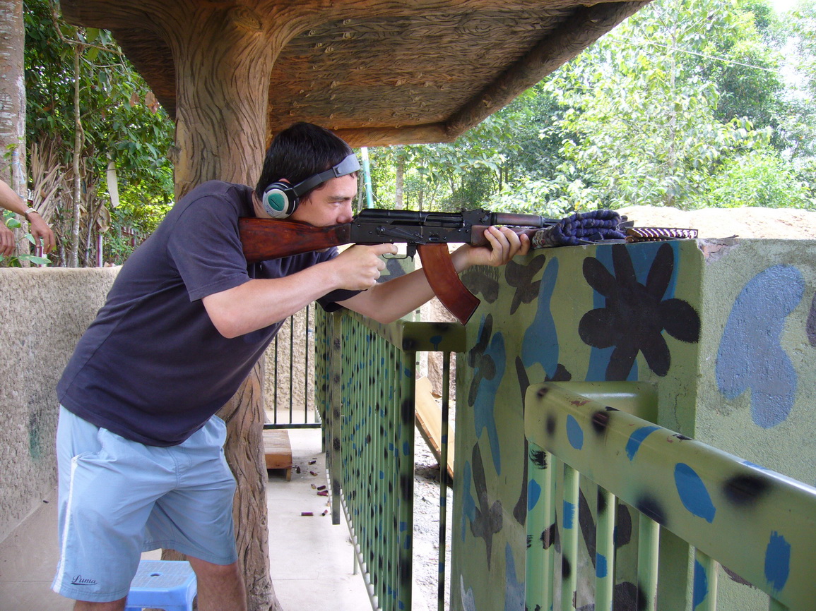 a man with headphones on his ears shooting an m - 15 rifle