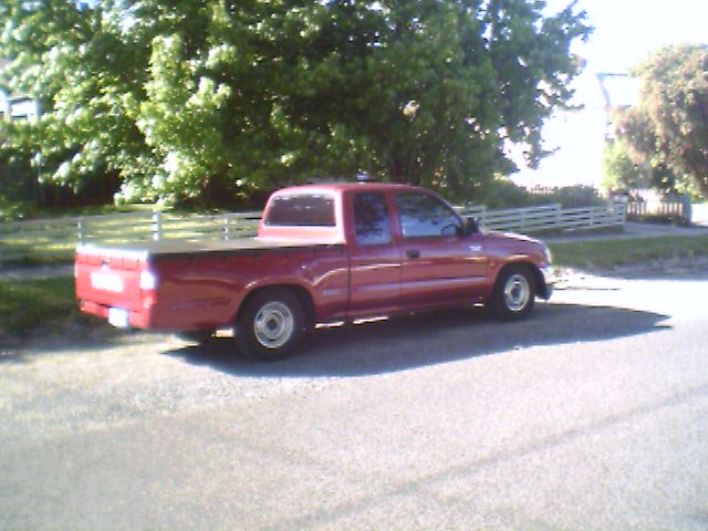 a red pickup truck parked on a residential street