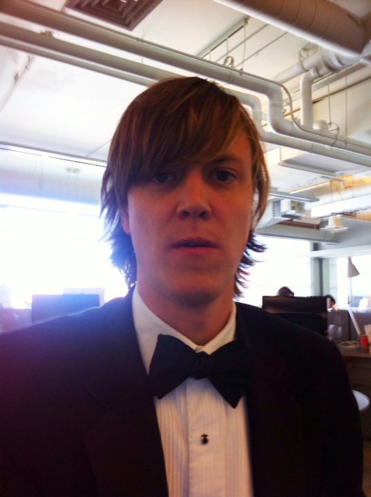 a person wearing a black suit and bow tie