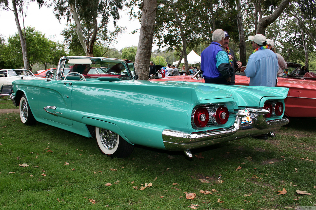 an old classic green car parked at a car show