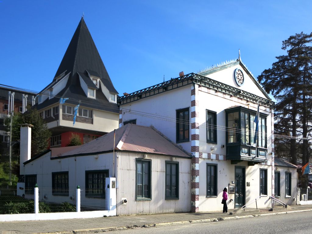 the corner of a road and building that has an old steeple and clock on the top