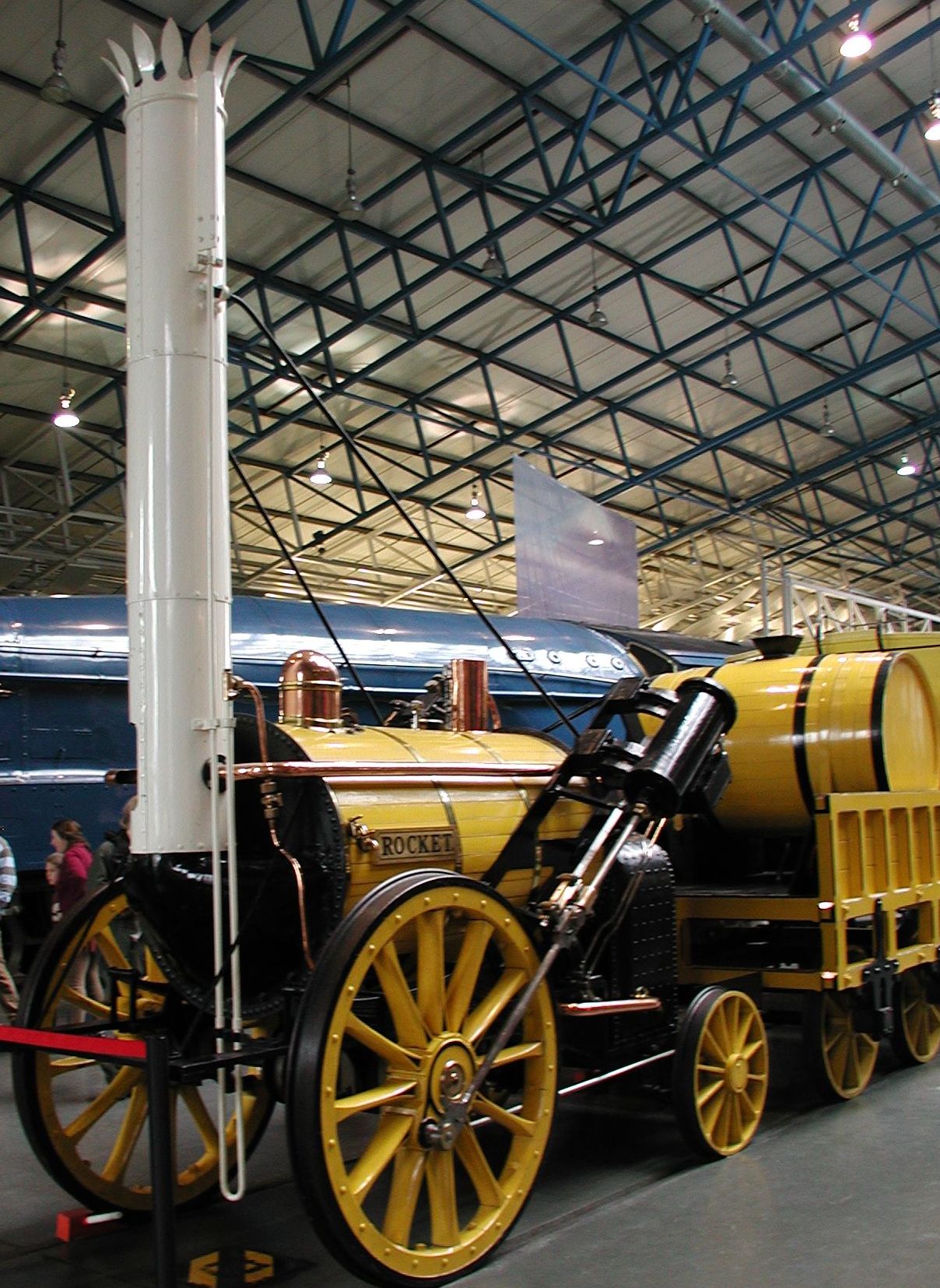 a yellow and black steam engine sitting under a covering