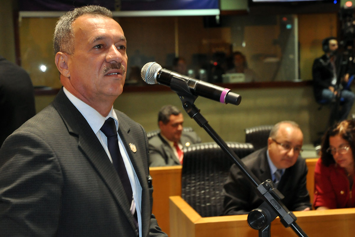 the man in a suit is standing in front of microphones