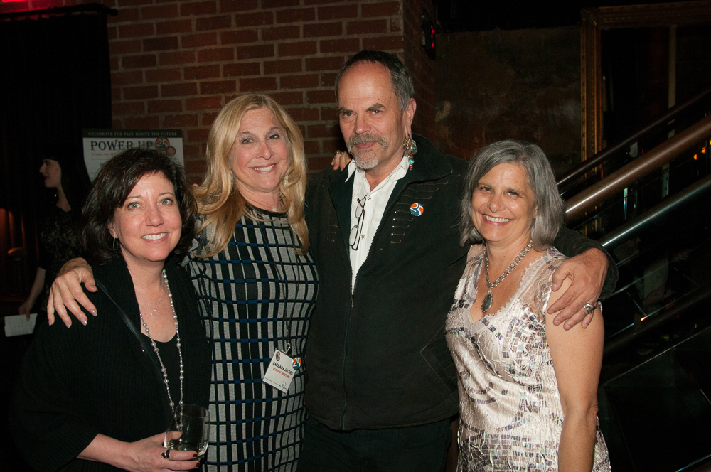 three women and one man posing for the camera