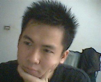 an asian man with spiked black hair in a room
