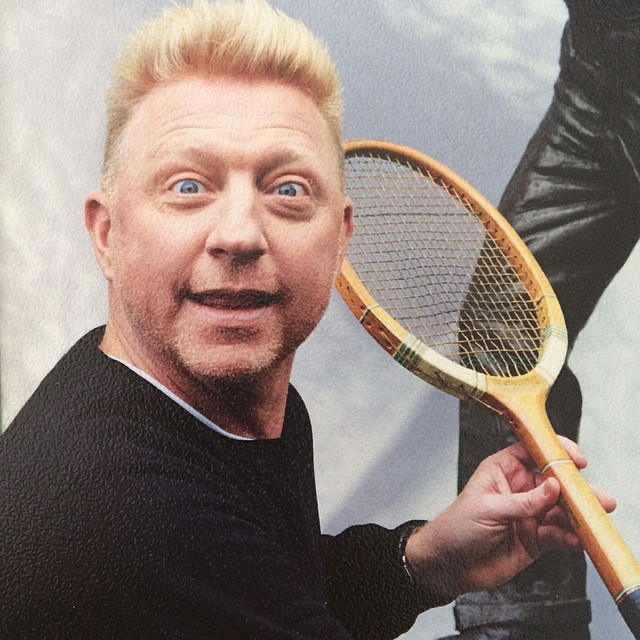 a man in black holding up a tennis racket
