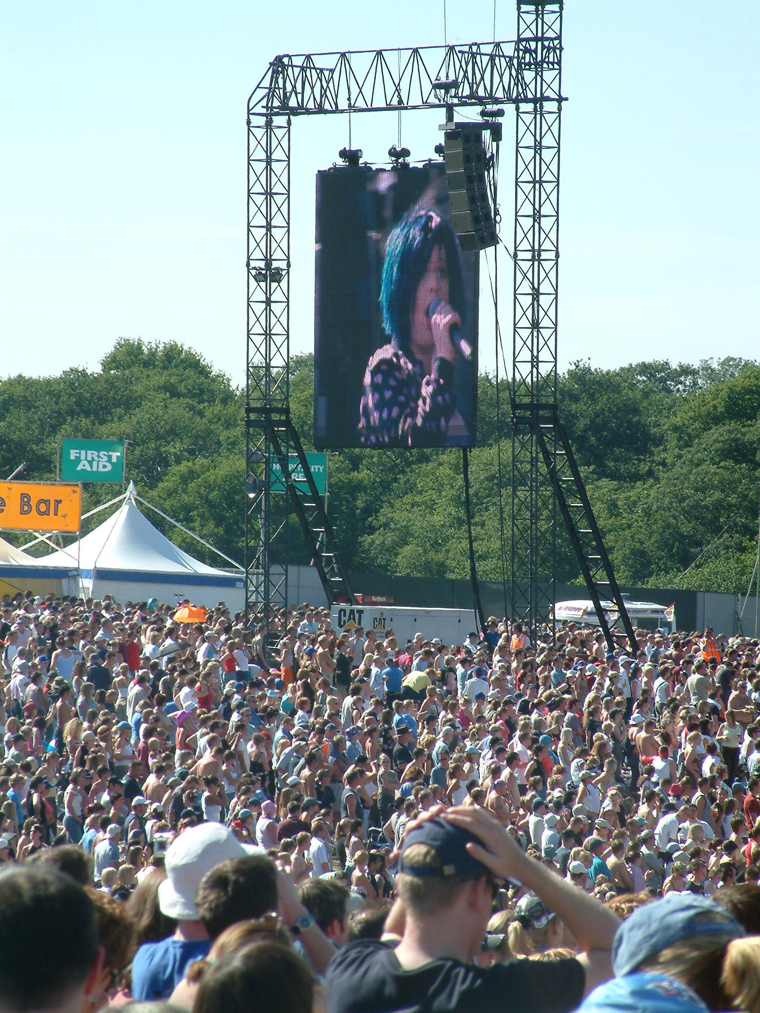 a large crowd watches a concert on a screen