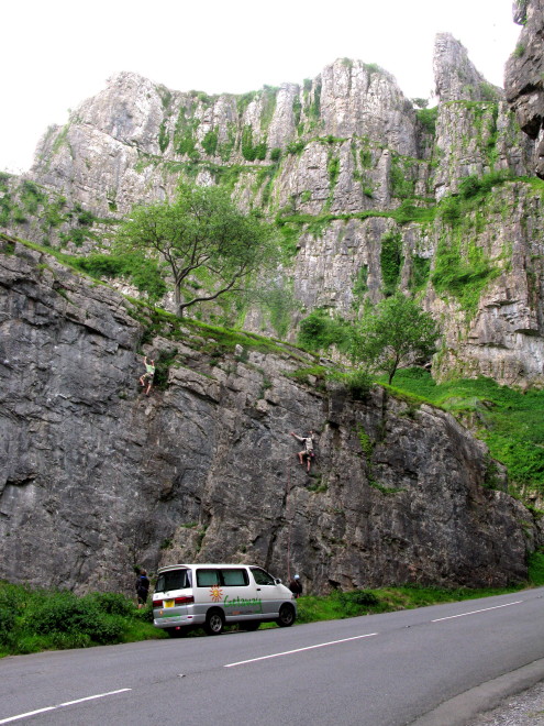 a white van drives down the road towards some mountains