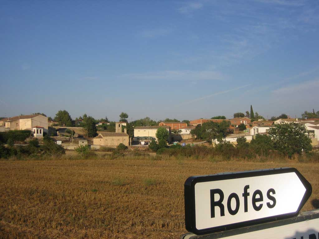 a field with houses and a sign in it