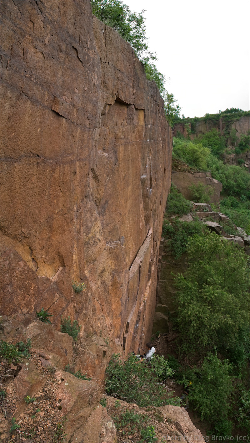 the side of a mountain covered in rock with trees on it