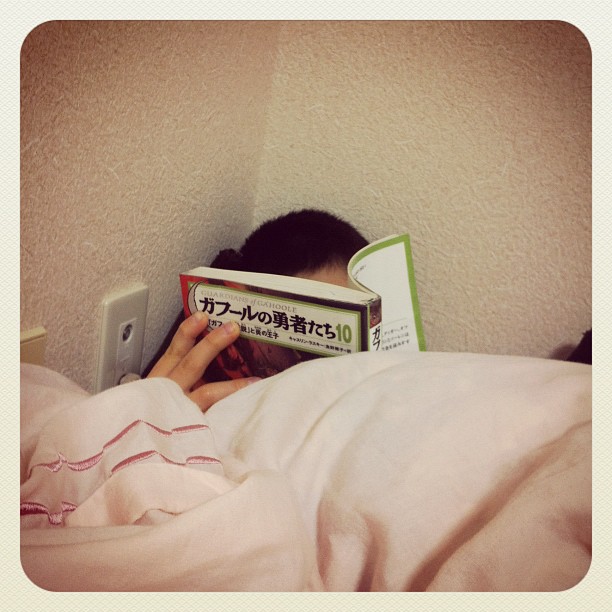 a person lying in bed reading a book