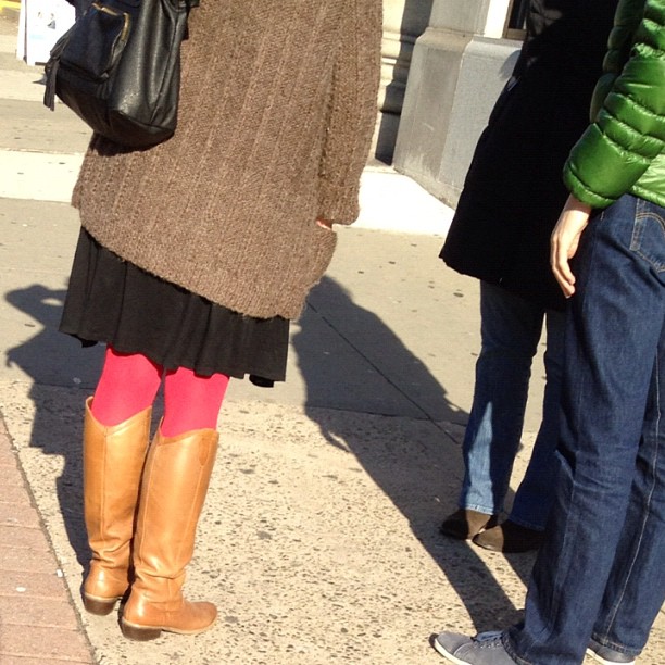 three people standing next to each other on a street