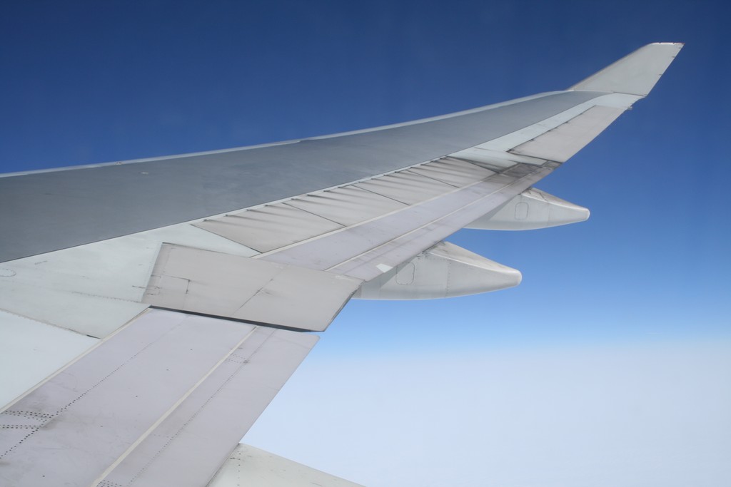 the wing of an airplane against a blue sky