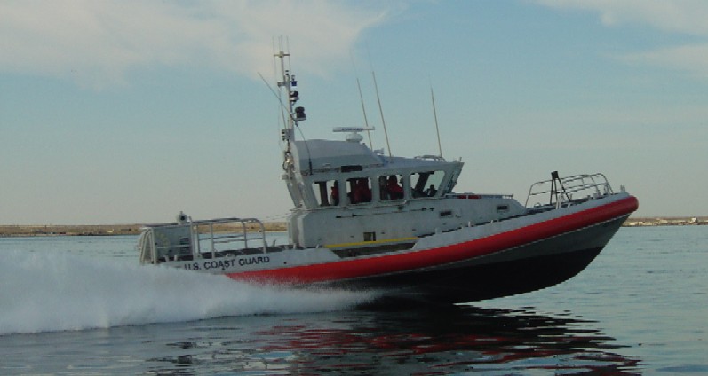 a red and white boat with a pilot on top