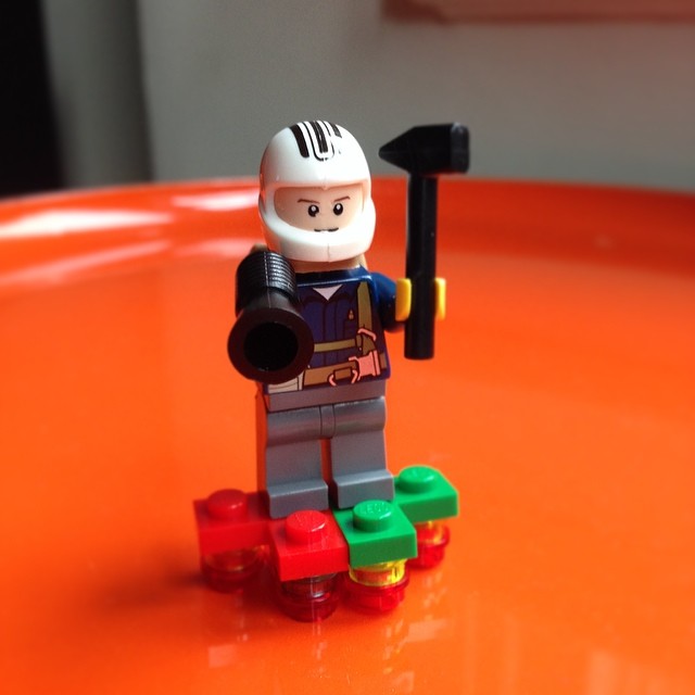 a lego figurine holding an ax with some bricks surrounding it